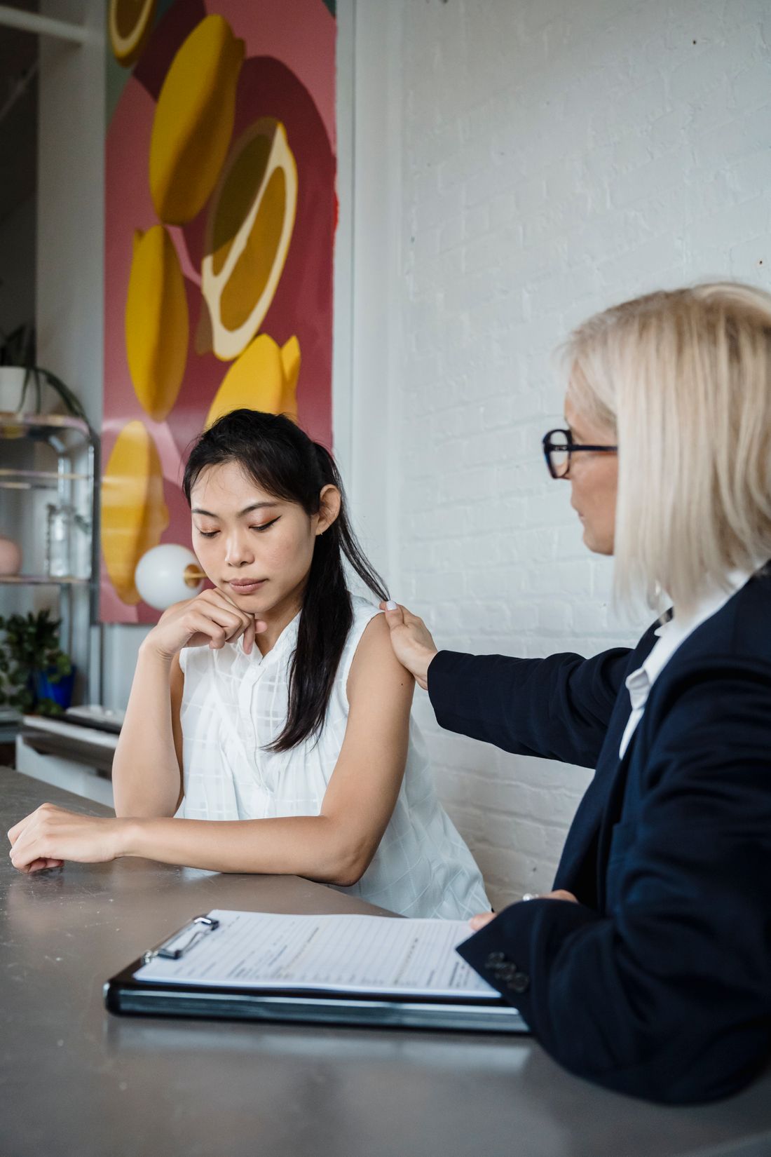 Two adults talking together with paperwork on a table